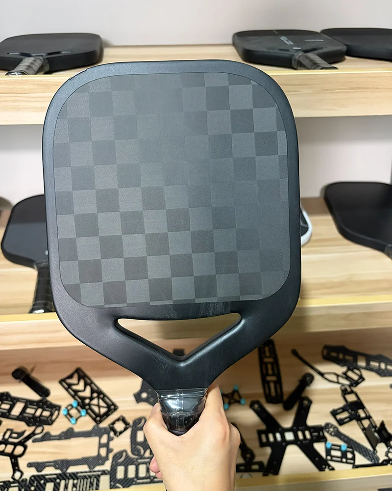 A high-end pickleball paddle featuring an 18K spread tow carbon fiber surface, offering an ultra-lightweight build with superior energy return and a sleek, professional aesthetic.