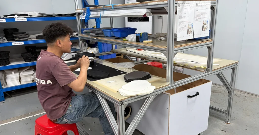 A skilled technician meticulously applying specialized structural adhesive to a precision-cut EPP honeycomb core, showcasing advanced bonding technology for high-end pickleball paddles.