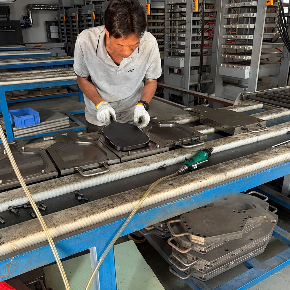 high-end-pickleball-paddle-thermoforming-process A skilled technician placing a carbon fiber paddle into a precision mold for the thermoforming process, creating a high-performance unibody structure.