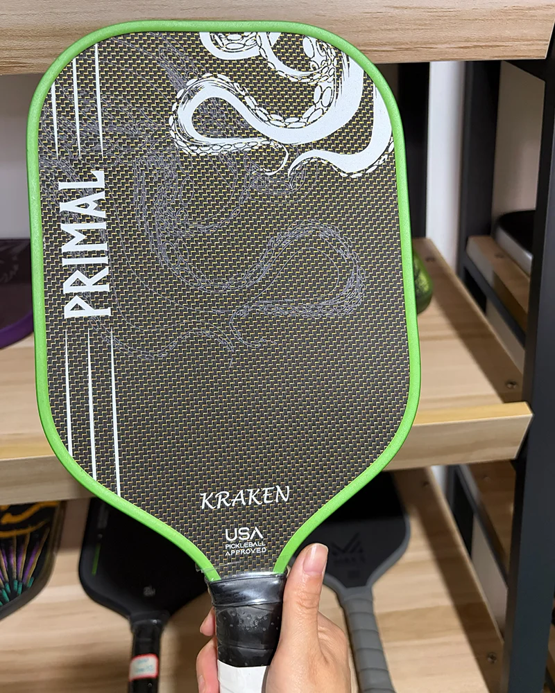 A close-up shot of a high-end pickleball paddle featuring a titanium wire mesh layer for enhanced structural integrity and increased surface tension.